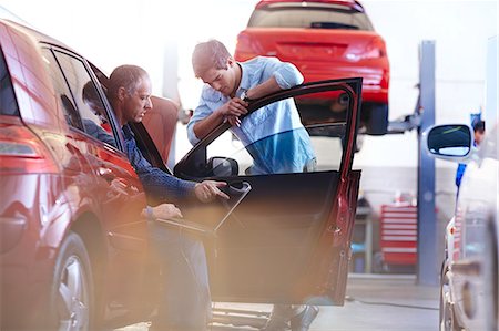 Mechanic with laptop talking to customer at car in auto repair shop Photographie de stock - Premium Libres de Droits, Code: 6113-08184369