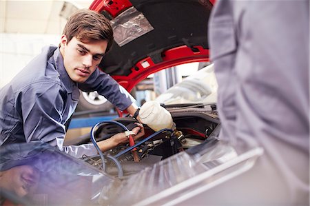 Mechanic working on car engine in auto repair shop Photographie de stock - Premium Libres de Droits, Code: 6113-08184371