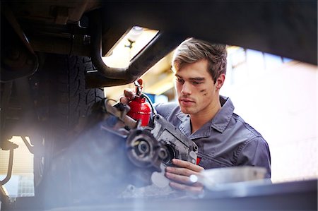 Mechanic oiling part in auto repair shop Stock Photo - Premium Royalty-Free, Code: 6113-08184387