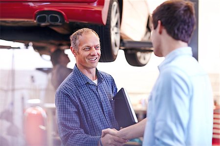 Mechanic and customer handshaking in auto repair shop Stock Photo - Premium Royalty-Free, Code: 6113-08184384