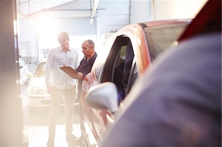 full body senior - Mechanic with clipboard talking to customer in auto repair shop Stock Photo - Premium Royalty-Free, Code: 6113-08184334