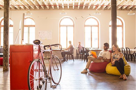 Creative business people using laptop on bean bag chairs in office Foto de stock - Sin royalties Premium, Código: 6113-08105352