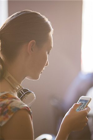 Close up woman with headphones using cell phone Foto de stock - Sin royalties Premium, Código: 6113-08105393