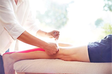 quiropráctico (hombre y mujer) - Physical therapist applying kinesiology tape to man's leg Foto de stock - Sin royalties Premium, Código: 6113-08105468