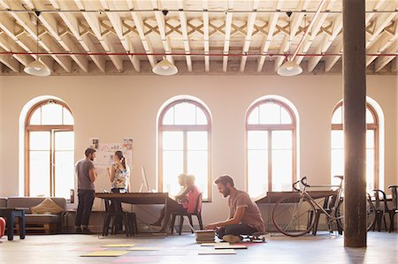 design and copy space - Creative businessman on skateboard working at laptop on floor in open office Stock Photo - Premium Royalty-Free, Code: 6113-08105429