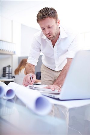 Focused architect drafting blueprint in office Stock Photo - Premium Royalty-Free, Code: 6113-08105510