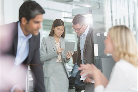 Business people sharing digital tablet in conference room Stock Photo - Premium Royalty-Free, Code: 6113-08220279