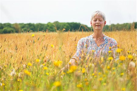 simsearch:6113-07906210,k - Senior woman meditating in rural field Foto de stock - Sin royalties Premium, Código: 6113-08220226