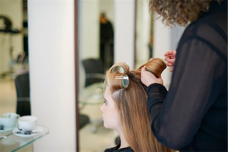 simsearch:6113-08220391,k - Hairdresser rolling customer's hair in curlers in salon Fotografie stock - Premium Royalty-Free, Codice: 6113-08220390