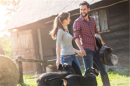 simsearch:6113-08220442,k - Couple with saddle and dogs holding hands outside rural barn Foto de stock - Sin royalties Premium, Código: 6113-08220399