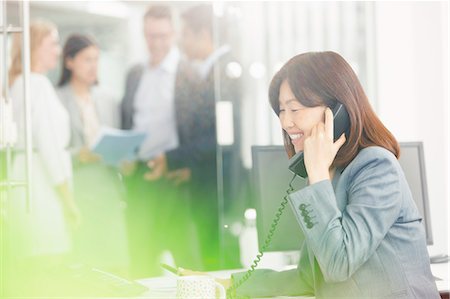 simsearch:6113-08220347,k - Smiling businesswoman talking on telephone in office Stock Photo - Premium Royalty-Free, Code: 6113-08220316