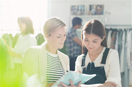 storage (office storage) - Fashion designers reviewing paperwork in office Photographie de stock - Premium Libres de Droits, Code: 6113-08220329