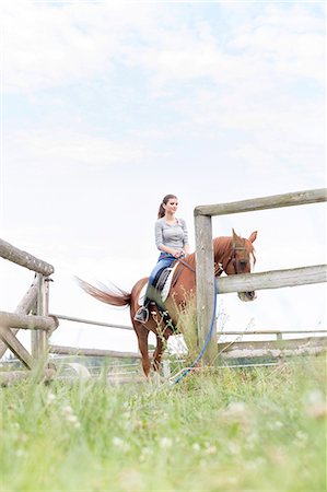 dressage - Woman horseback riding in fenced rural pasture Photographie de stock - Premium Libres de Droits, Code: 6113-08220443