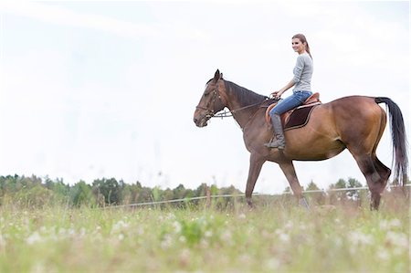 Woman horseback riding in rural field Photographie de stock - Premium Libres de Droits, Code: 6113-08220447