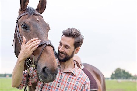 simsearch:6113-08220442,k - Smiling man hugging horse Foto de stock - Sin royalties Premium, Código: 6113-08220453