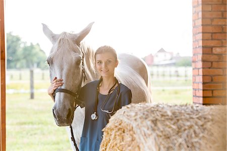 simsearch:6113-08220446,k - Portrait smiling veterinarian with horse in barn Photographie de stock - Premium Libres de Droits, Code: 6113-08220450