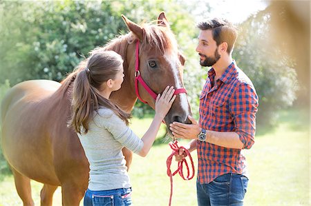 simsearch:400-05243571,k - Couple petting horse Photographie de stock - Premium Libres de Droits, Code: 6113-08220404