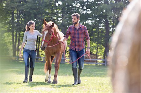 Couple walking horse in rural pasture Photographie de stock - Premium Libres de Droits, Code: 6113-08220406