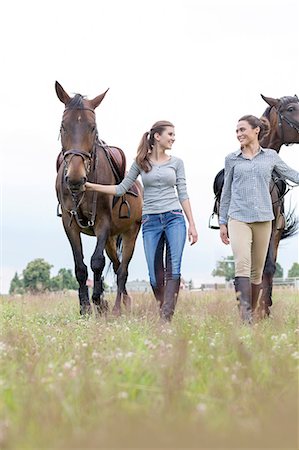 simsearch:6113-08220442,k - Women walking horses in rural field Foto de stock - Sin royalties Premium, Código: 6113-08220423