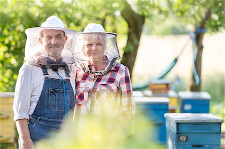 simsearch:6113-08220461,k - Portrait confident beekeepers in protective hats near hives Photographie de stock - Premium Libres de Droits, Code: 6113-08220503