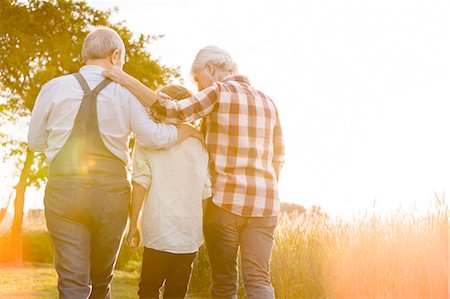 Affectionate grandparents and grandson walking along sunny rural wheat field Stock Photo - Premium Royalty-Free, Code: 6113-08220500