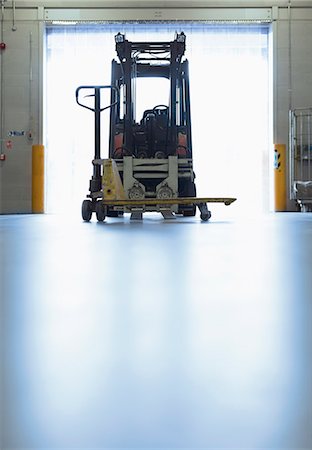 Forklift parked in warehouse loading dock doorway Foto de stock - Sin royalties Premium, Código: 6113-08393576