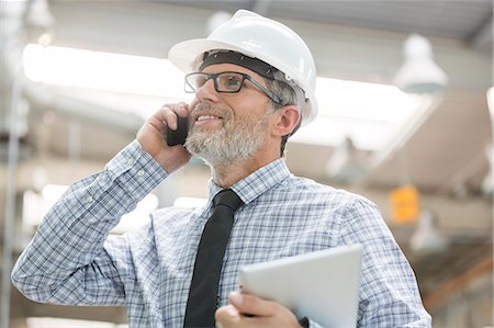 simsearch:6113-07564982,k - Engineer with hard-hat and digital tablet talking on cell phone Stock Photo - Premium Royalty-Free, Code: 6113-08393848