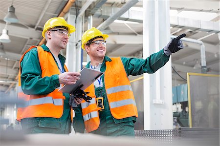 security - Workers in protective workwear talking with clipboard in factory Stock Photo - Premium Royalty-Free, Code: 6113-08393861
