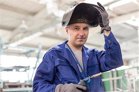 Portrait confident welder with welding torch in factory Foto de stock - Sin royalties Premium, Código: 6113-08393862