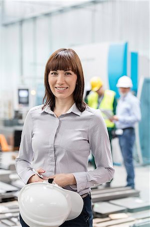 power woman 40 - Portrait smiling engineer with hard-hat in factory Photographie de stock - Premium Libres de Droits, Code: 6113-08393877