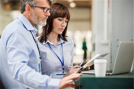 Business people with clipboard working at laptop in factory Photographie de stock - Premium Libres de Droits, Code: 6113-08393888