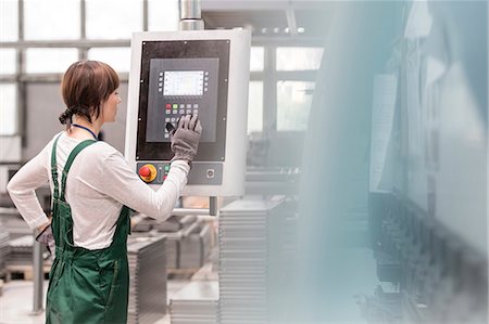 Worker at control panel operating machinery in factory Photographie de stock - Premium Libres de Droits, Code: 6113-08393833