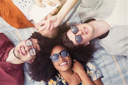 dominikaner (männlich und weiblich) - Overhead portrait smiling friends laying in circle on blanket Stockbilder - Premium RF Lizenzfrei, Bildnummer: 6113-08321166