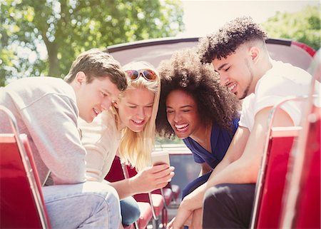 Friends texting with cell phone on double-decker bus Stock Photo - Premium Royalty-Free, Code: 6113-08321169