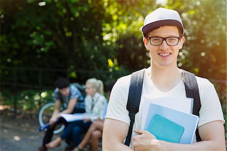 simsearch:6113-07542440,k - Portrait smiling college student with books in park Foto de stock - Royalty Free Premium, Número: 6113-08321179