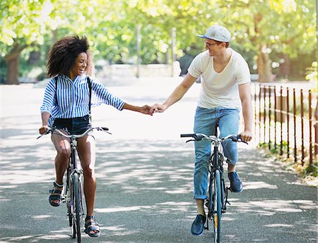 dominican - Couple holding hands riding bicycles in urban park Photographie de stock - Premium Libres de Droits, Code: 6113-08321117