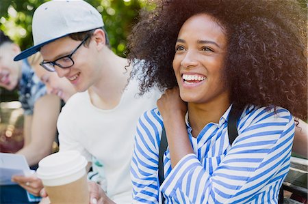 simsearch:6113-08321133,k - Smiling woman with afro drinking coffee with friends outdoors Stock Photo - Premium Royalty-Free, Code: 6113-08321123
