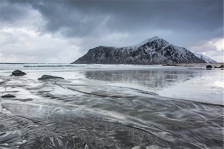 skagsanden beach - Snow covered rock formation on cold ocean beach, Skagsanden Beach, Lofoten Islands, Norway Stock Photo - Premium Royalty-Free, Code: 6113-08321251