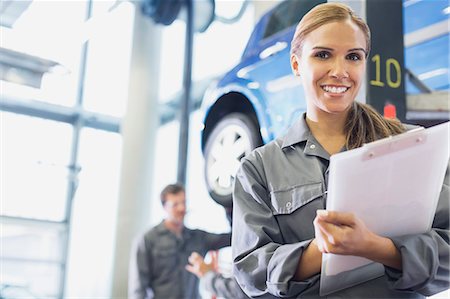 female mechanic portrait - Portrait smiling mechanic with clipboard in auto repair shop Photographie de stock - Premium Libres de Droits, Code: 6113-08321353