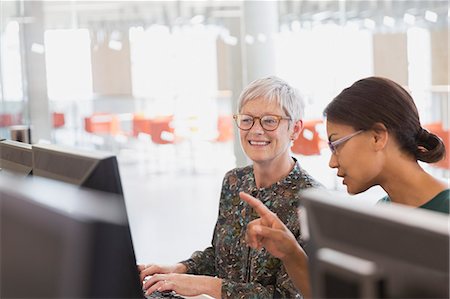 professor with student - Women working at computers in adult education classroom Stock Photo - Premium Royalty-Free, Code: 6113-08321364