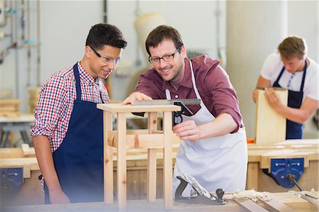 student apron - Carpenters measuring wood in workshop Stock Photo - Premium Royalty-Free, Code: 6113-08321398