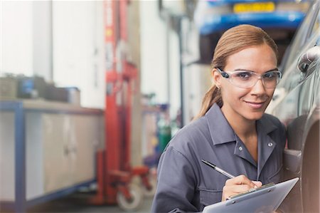 simsearch:6113-07564950,k - Portrait confident female mechanic with clipboard in auto repair shop Foto de stock - Sin royalties Premium, Código: 6113-08321399