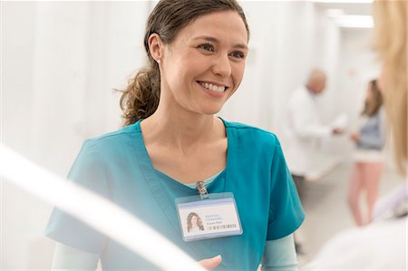 Smiling nurse talking to doctor in hospital corridor Photographie de stock - Premium Libres de Droits, Code: 6113-08321310