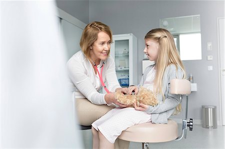 simsearch:6113-08321321,k - Pediatrician using stethoscope on girl patient's teddy bear in examination room Photographie de stock - Premium Libres de Droits, Code: 6113-08321320