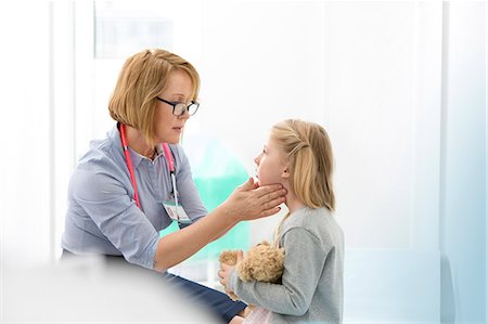 female doctor and child patient - Pediatrician checking girl patient's glands in examination room Foto de stock - Sin royalties Premium, Código: 6113-08321335