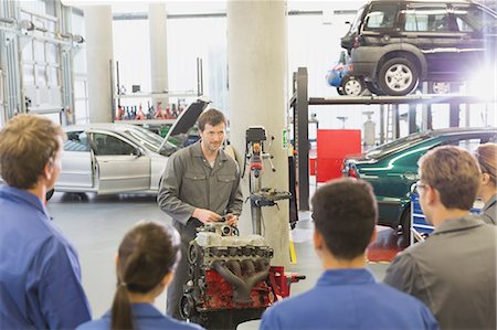 simsearch:6113-08321353,k - Mechanic explaining car engine to students in auto repair shop Foto de stock - Sin royalties Premium, Código: 6113-08321405