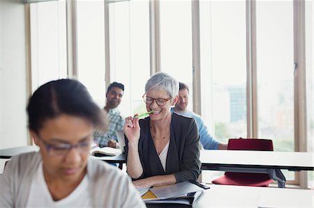 Smiling senior woman studying in adult education classroom Photographie de stock - Premium Libres de Droits, Code: 6113-08321412