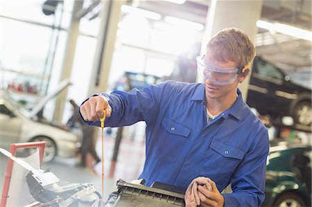 simsearch:6113-08321433,k - Mechanic checking engine oil in auto repair shop Stock Photo - Premium Royalty-Free, Code: 6113-08321501