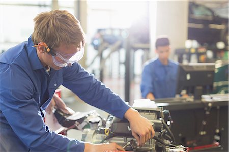 simsearch:6113-08321475,k - Mechanic working on engine in auto repair shop Stock Photo - Premium Royalty-Free, Code: 6113-08321504