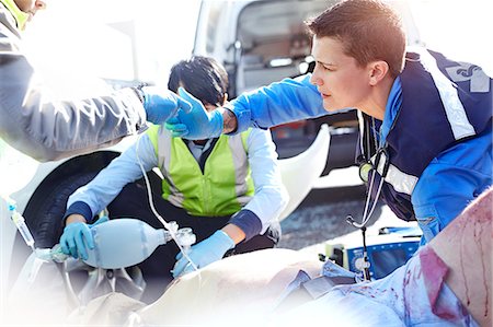 simsearch:6113-08321694,k - Rescue workers with manual resuscitator over car accident victim in road Foto de stock - Sin royalties Premium, Código: 6113-08321695